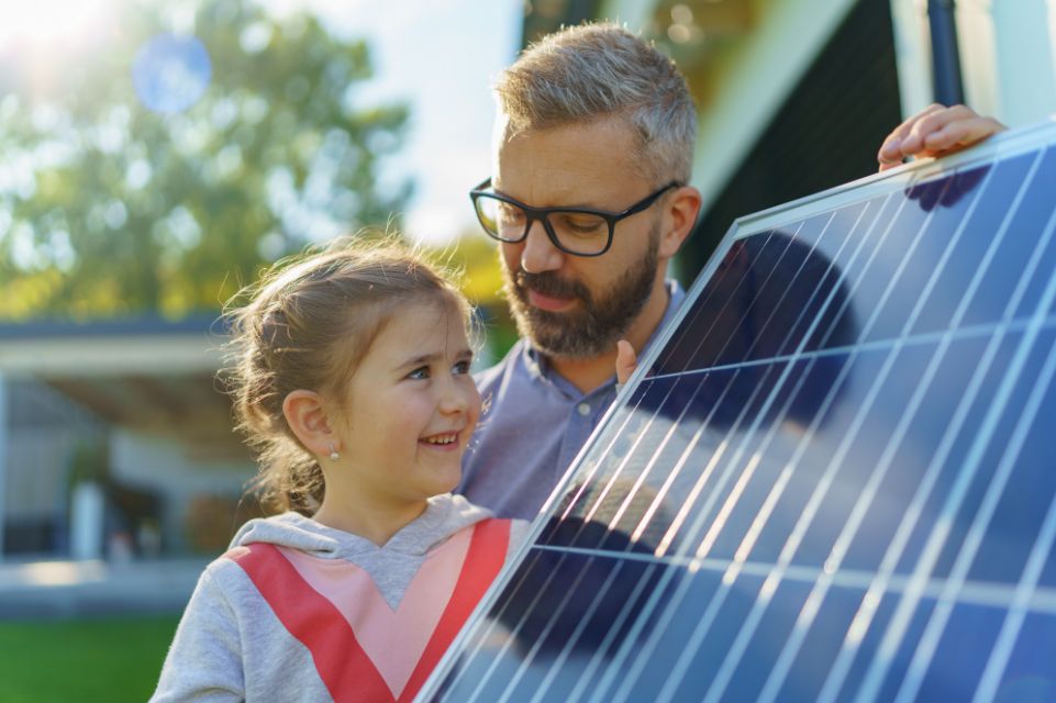Man and daughter view solar panel