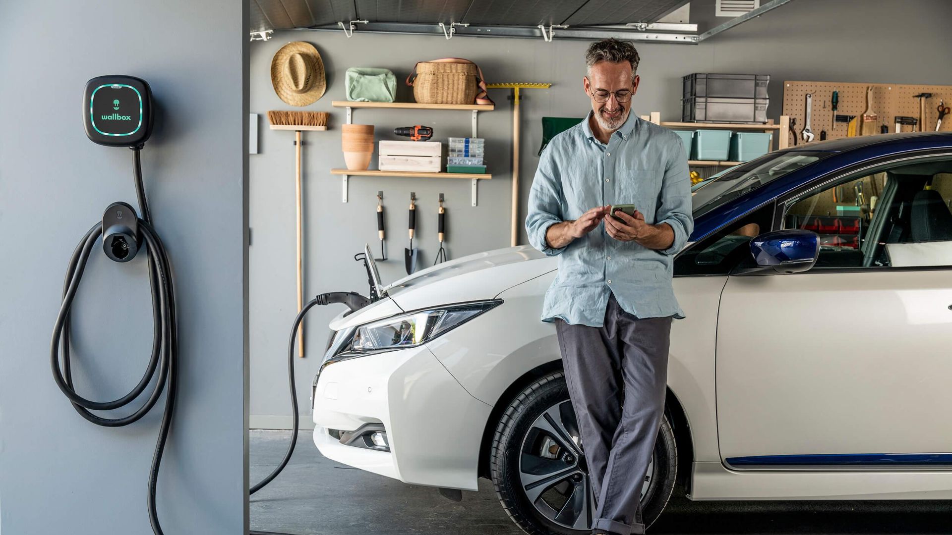 Man stands by EB in Garage with EV Charger