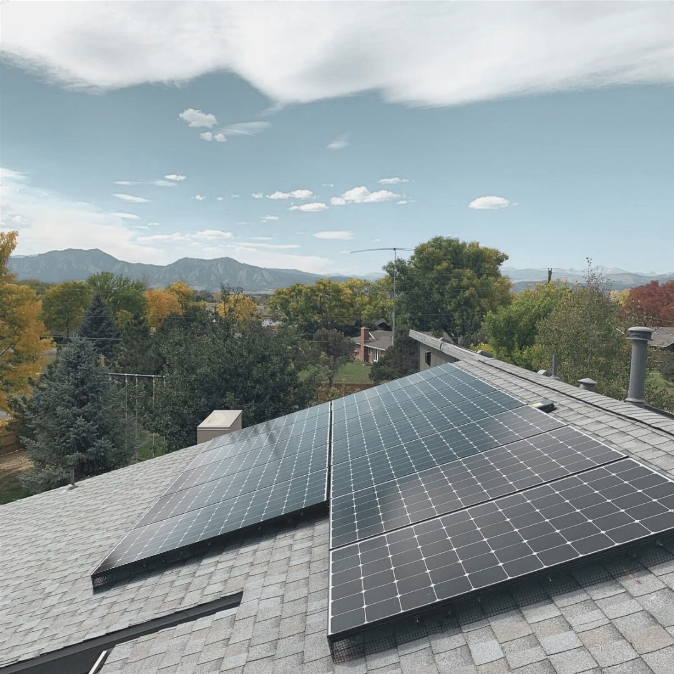 photo of solar panels on roof with flatirons in background