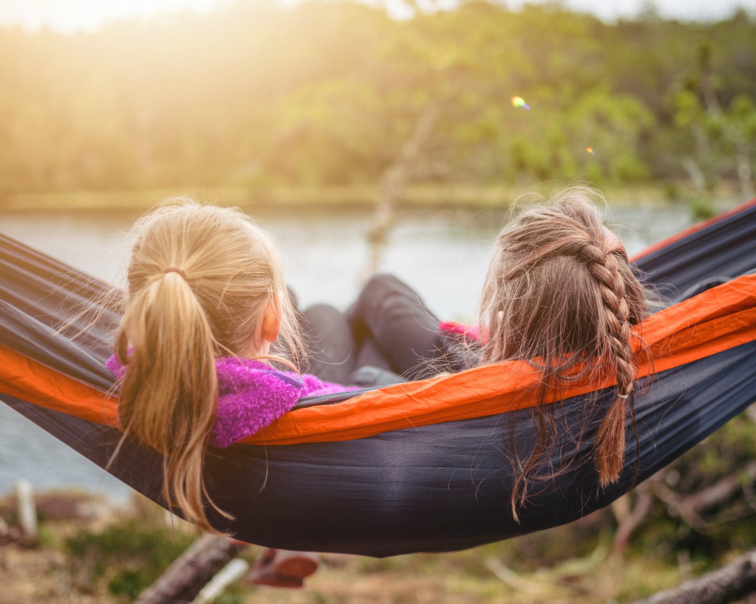 2 young children relax together in a hammock
